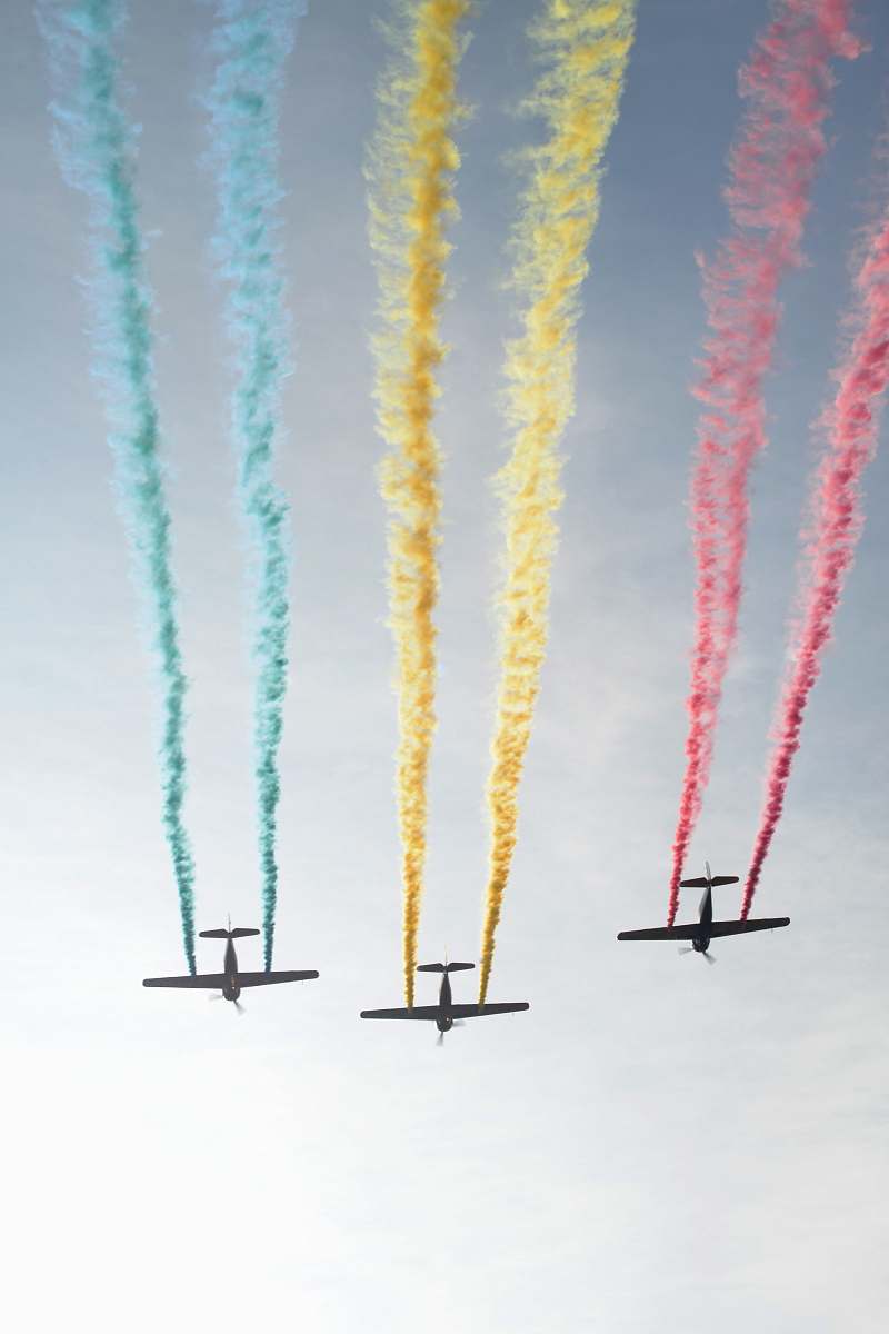 sky photograph of three plain releasing colorful smokes airplane