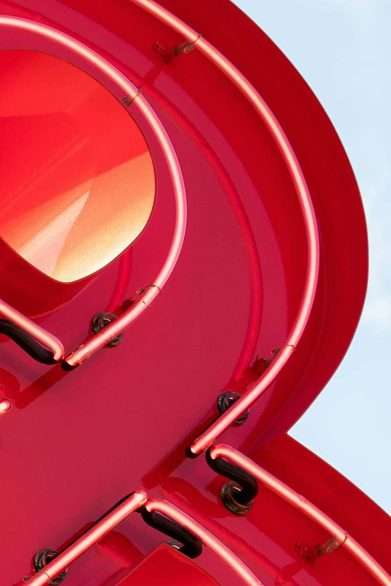 handrail closeup photo of red neon signage banister