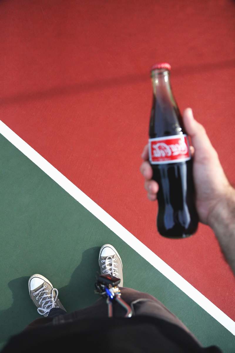 apparel person holding Coca-Cola bottle footwear