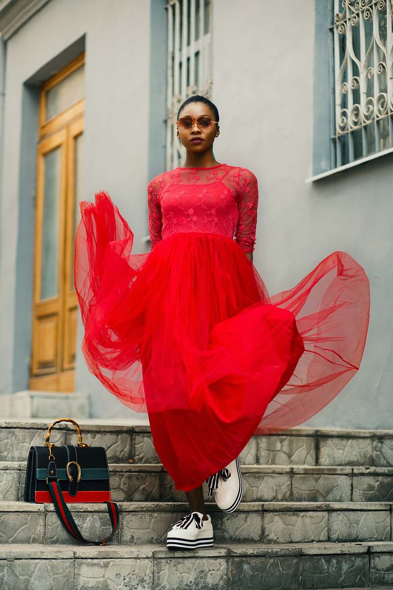 apparel woman wearing red maxi dress during daytime footwear