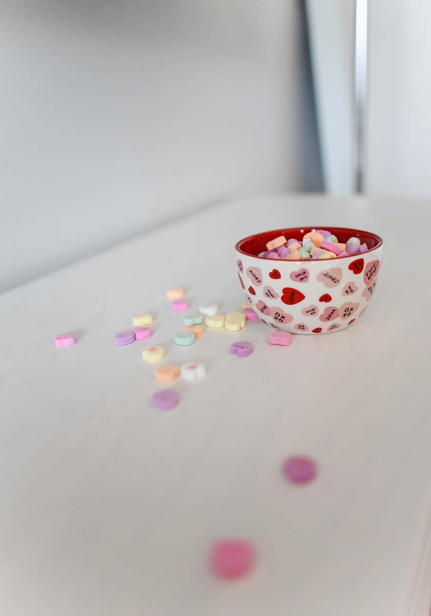sweets white and red ceramic bowl on white surface candy