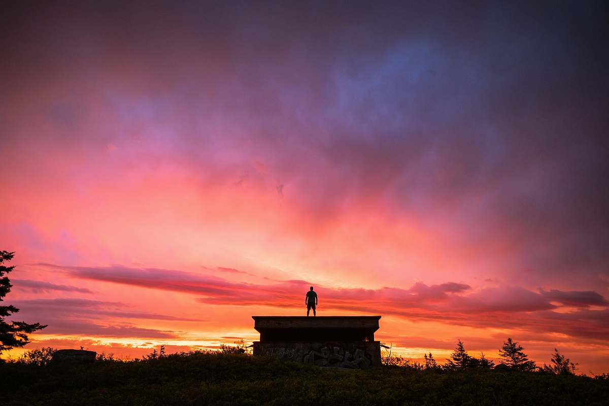 sunrise silhouette of person standing on the roof of the house sky