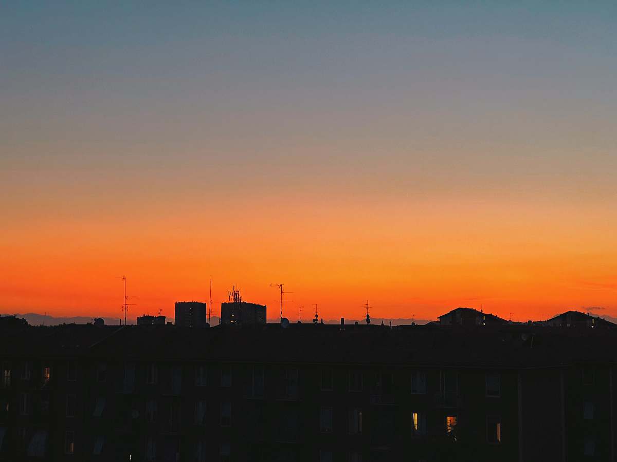 nature silhouette photography of houses during golden hour sky