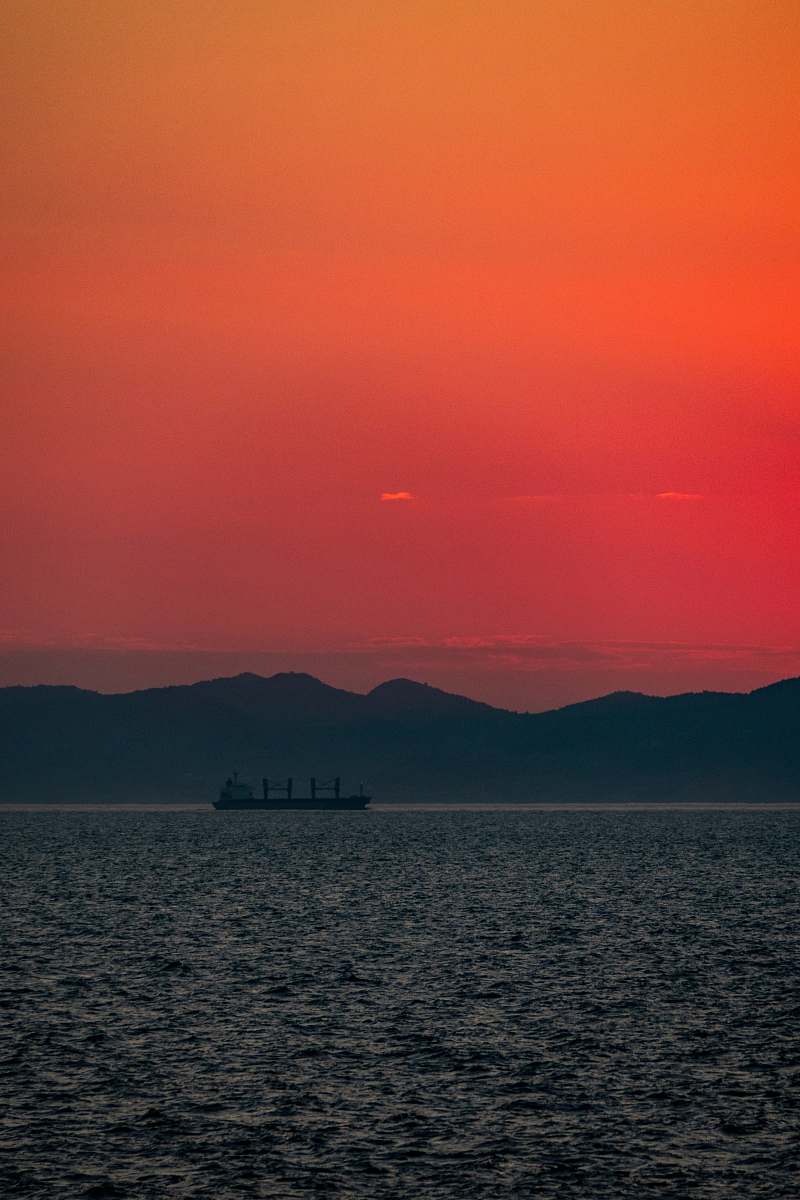 nature sillhoutte photography of ship in the sea during golden hour sky