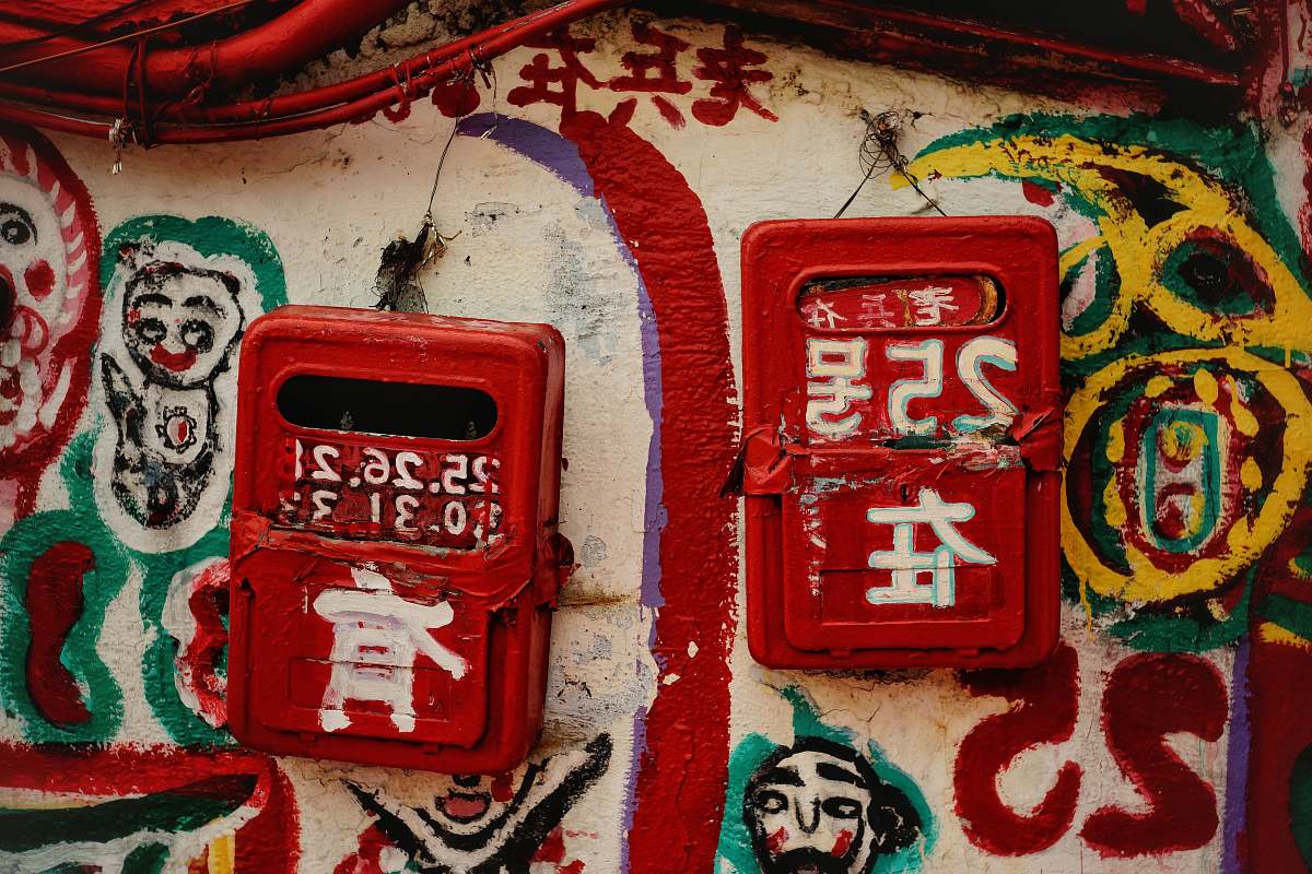 Explore a captivating urban scene featuring two striking red cases mounted on a wall, adorned with intricate graffiti art, alongside a classic red telephone box also covered in colorful street art. This visually dynamic composition is perfect for projects related to urban culture, street art, or modern city life, making it an ideal choice for designers, marketers, and art enthusiasts seeking to convey creativity and vibrancy.