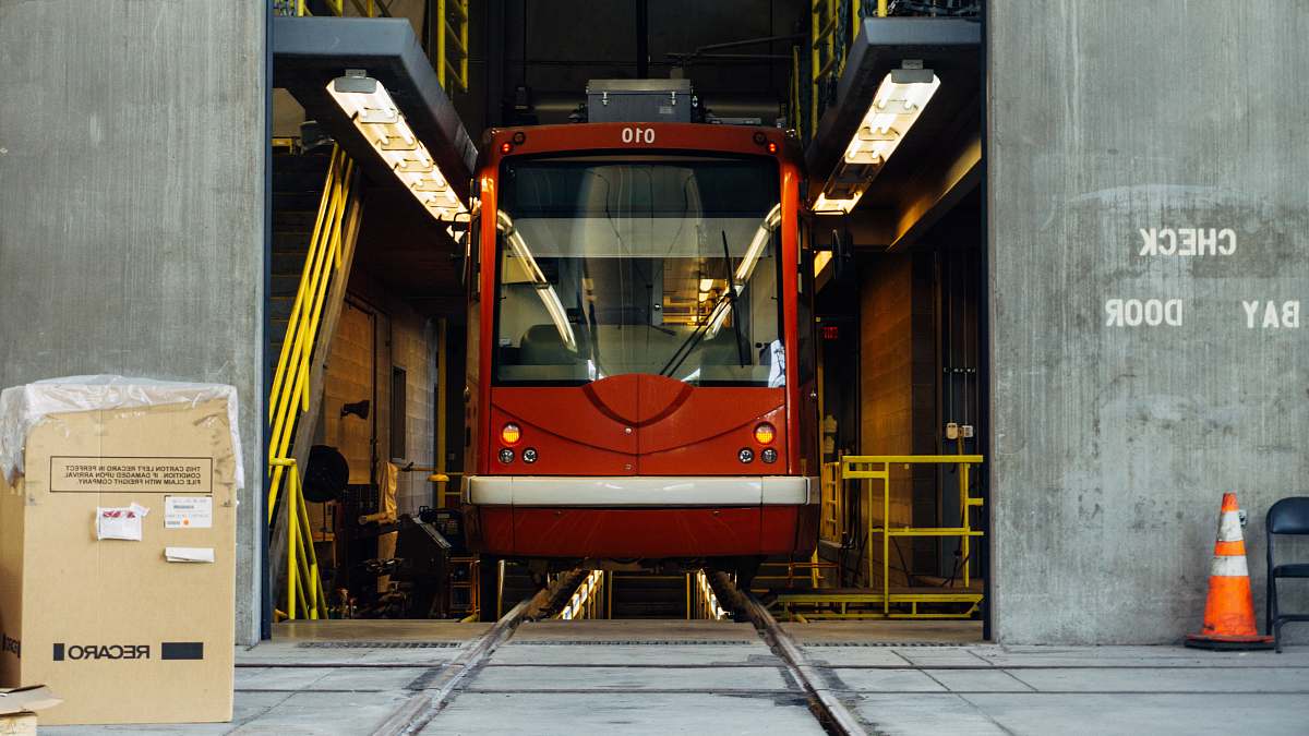 transportation red train in between gray concrete wall box
