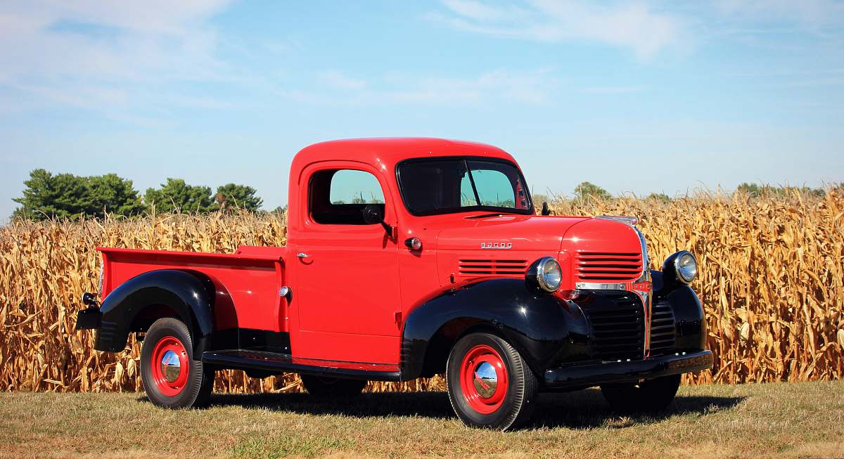 truck red and black single cab pickup truck beside a corn field pickup truck