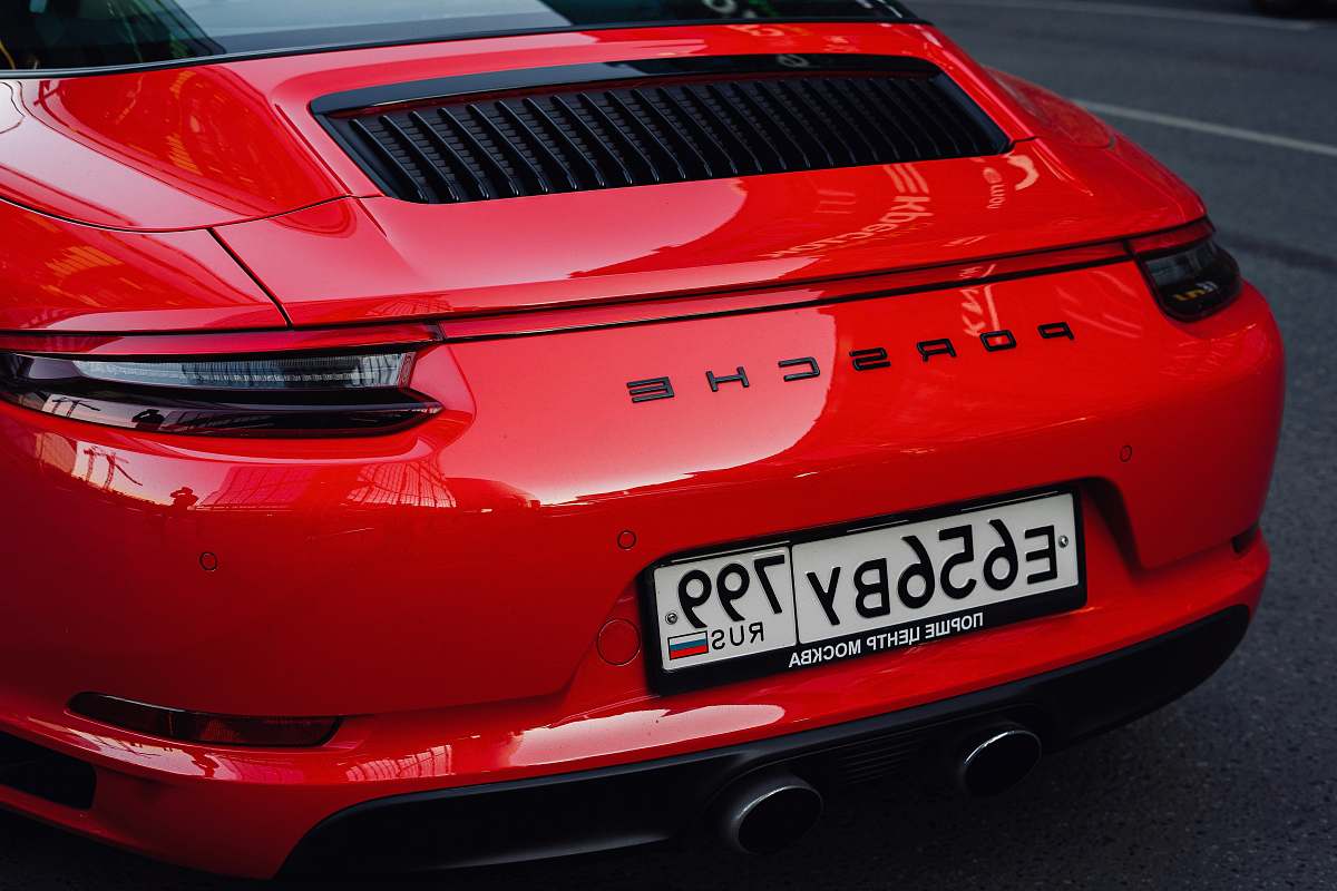 automobile red Porsche car on paved road car