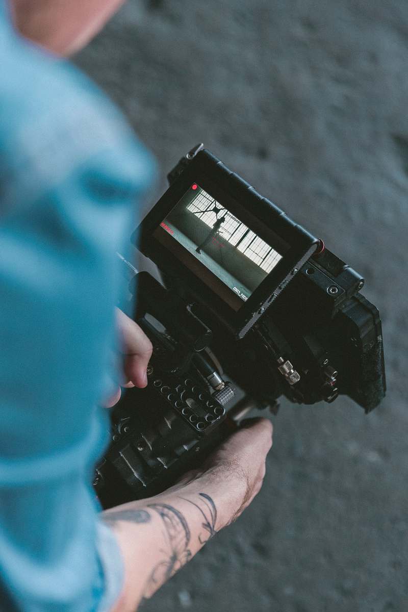 cinematography person holding black DSLR camera video camera