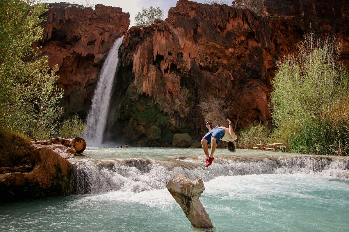 river man diving on water near falls waterfall