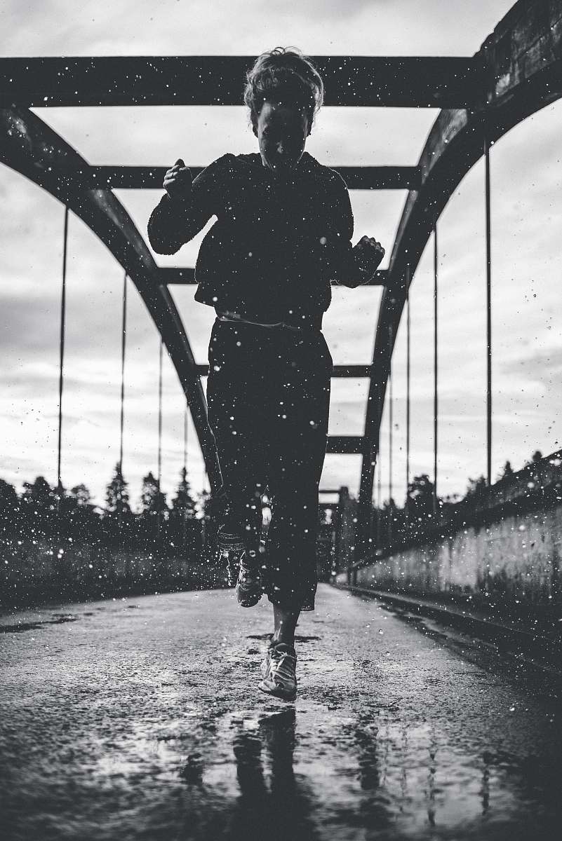 people greyscale photography of woman running on bridge person