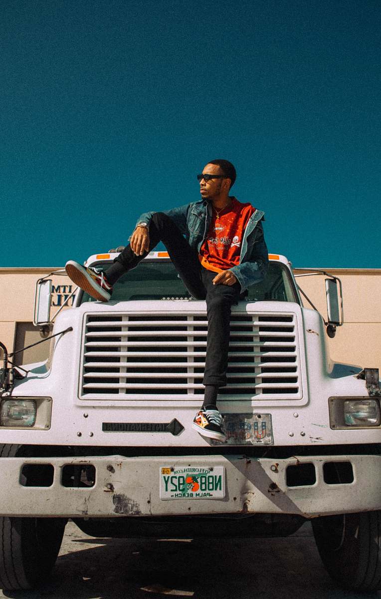 people man sitting on top of freight truck bumper with one foot up person