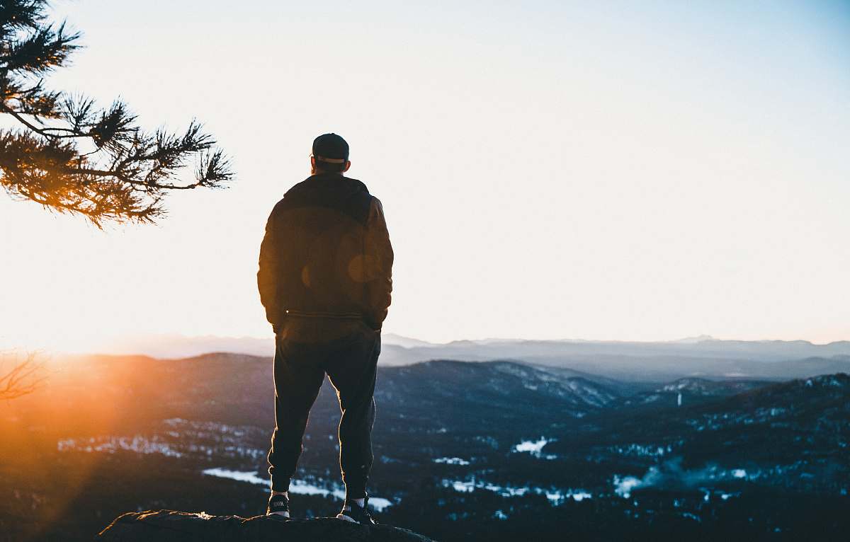 people man standing on cliff mountains overview person