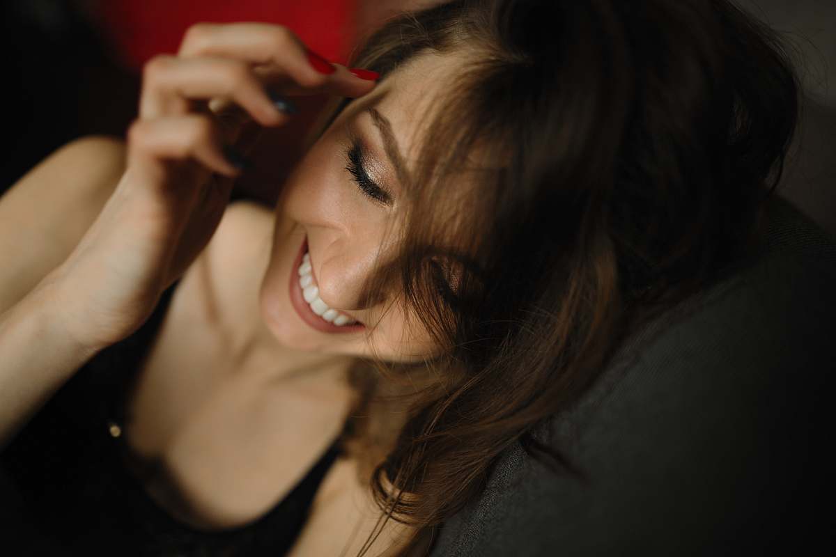 people woman sitting smiling and holding her hair person