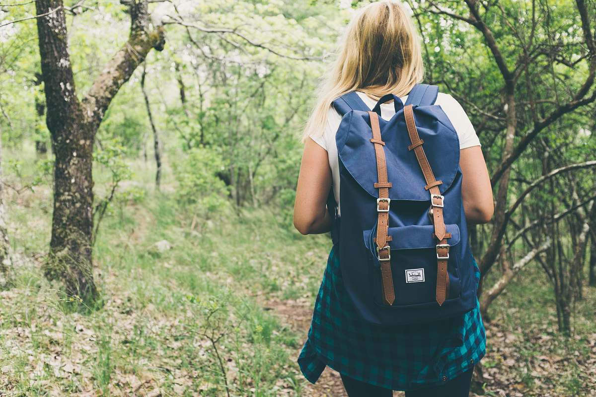 people woman wearing backpack walking on forest person