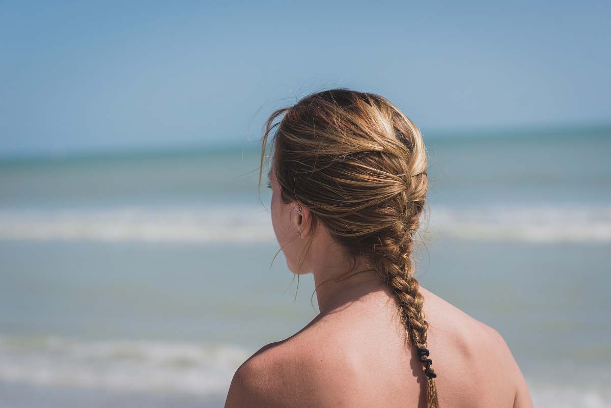 person back view photo of woman with braided hair near sea woman