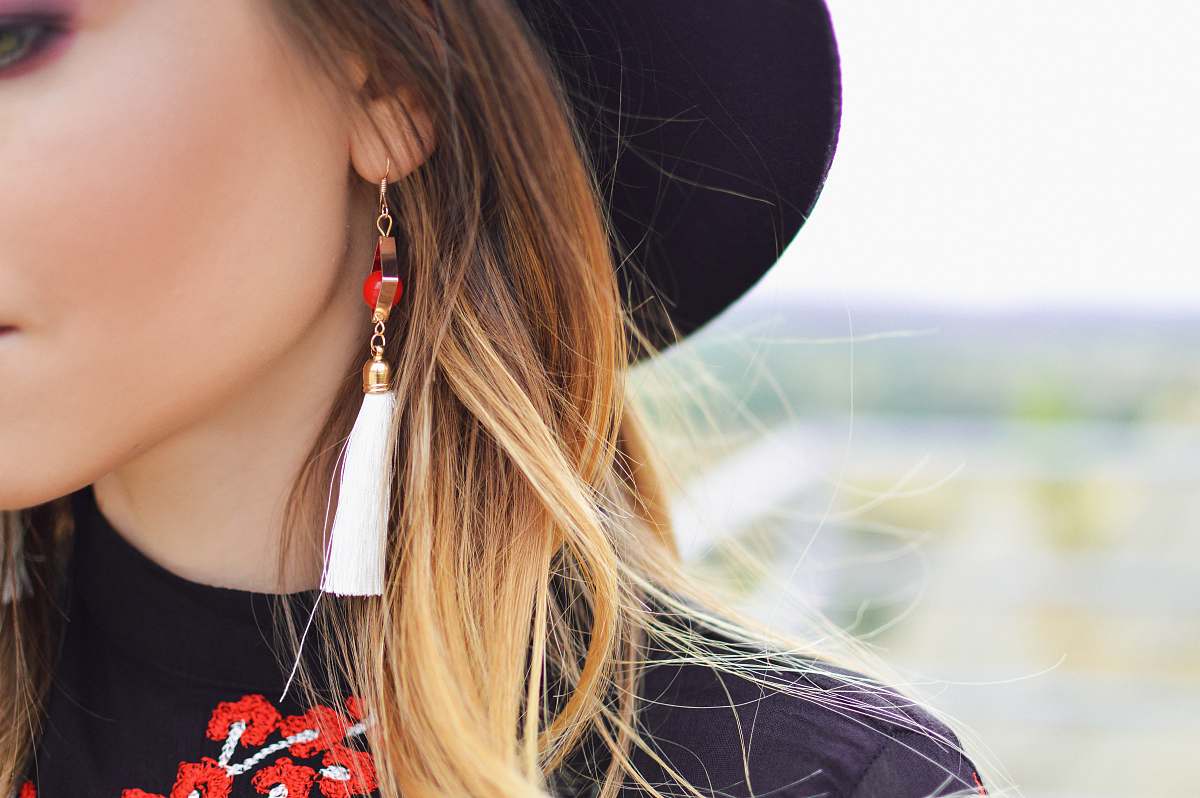 human blonde haired woman in white tassel dangling earring woman