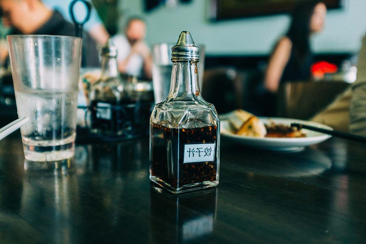human clear glass condiments container on black wooden board beverage