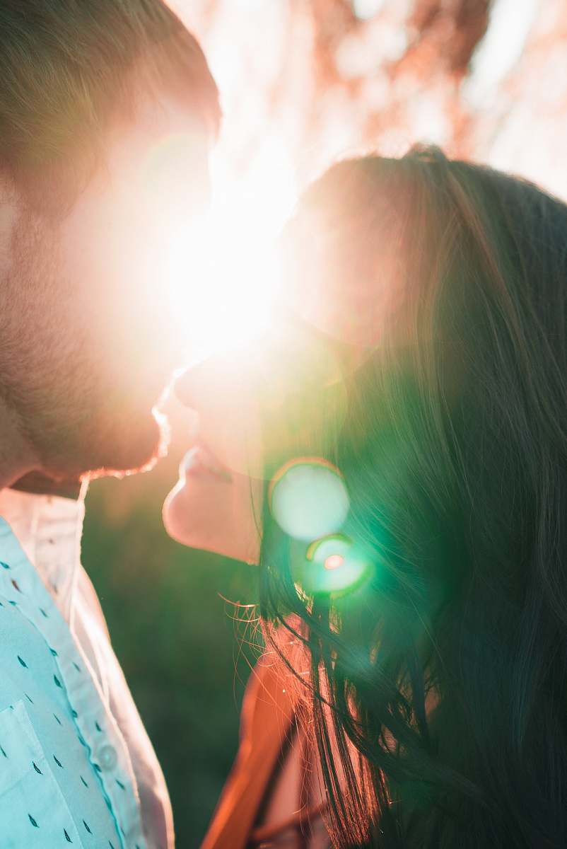 person couple kissing during golden hour human