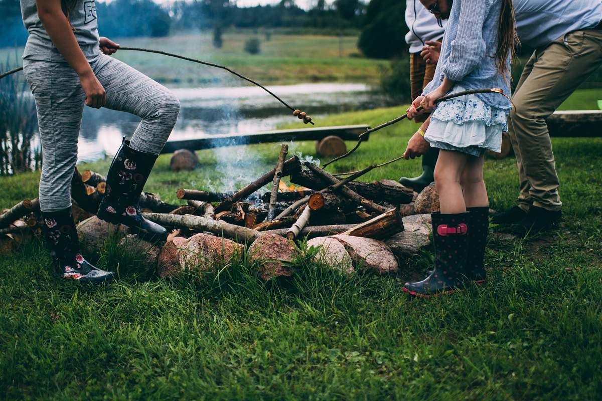 person family camping near body of water during daytime human