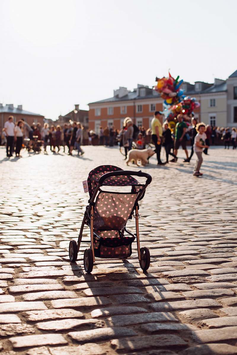 person gray and white polka-dot stroller in the middle of street stroller