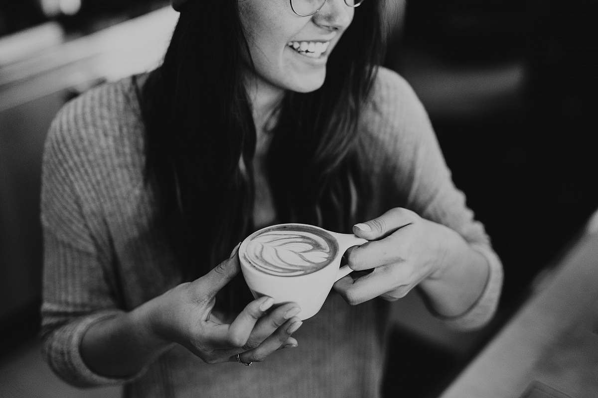 person grayscale photo of woman holding coffee black-and-white