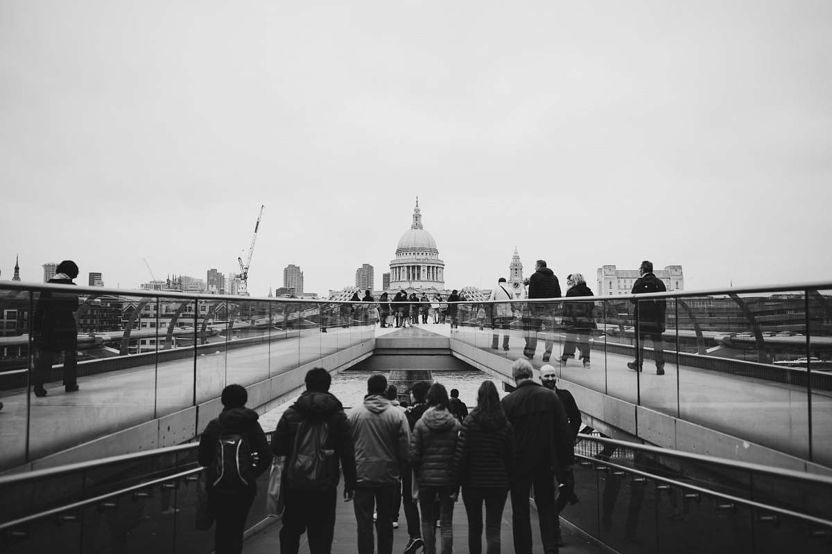 human grayscale photo standing near church black-and-white