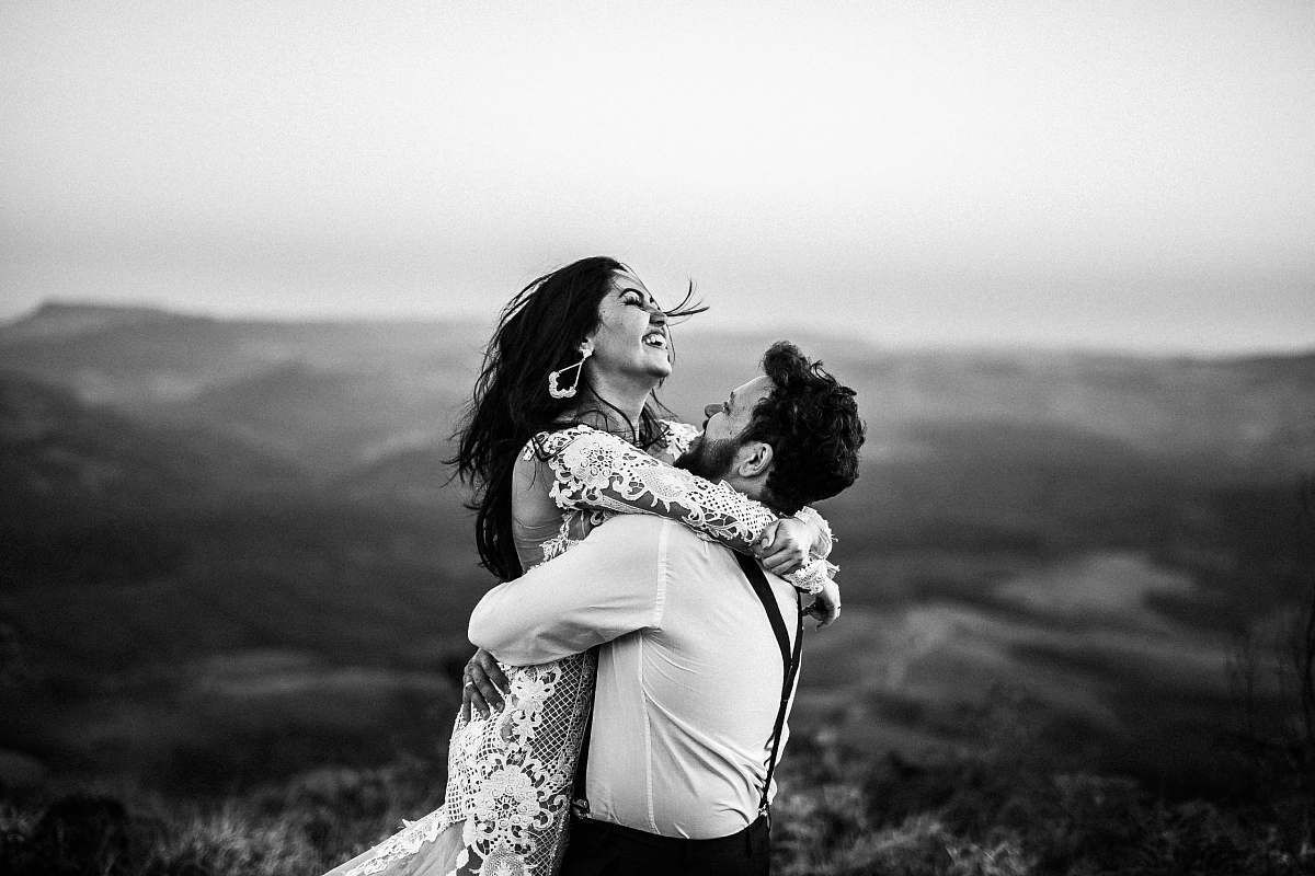 human grayscale photography of man and woman hugging near hill black-and-white