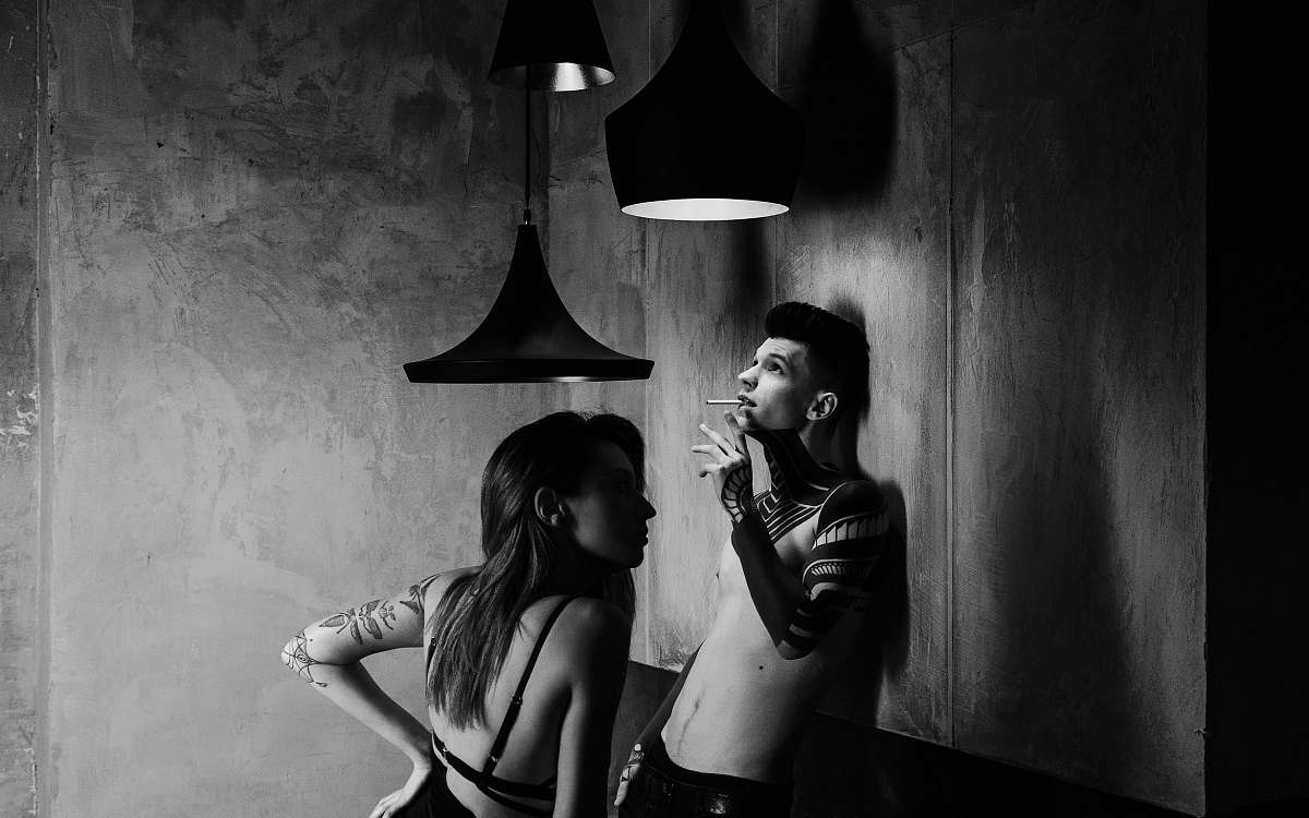 human grayscale photography of smoking man in front of girl black-and-white