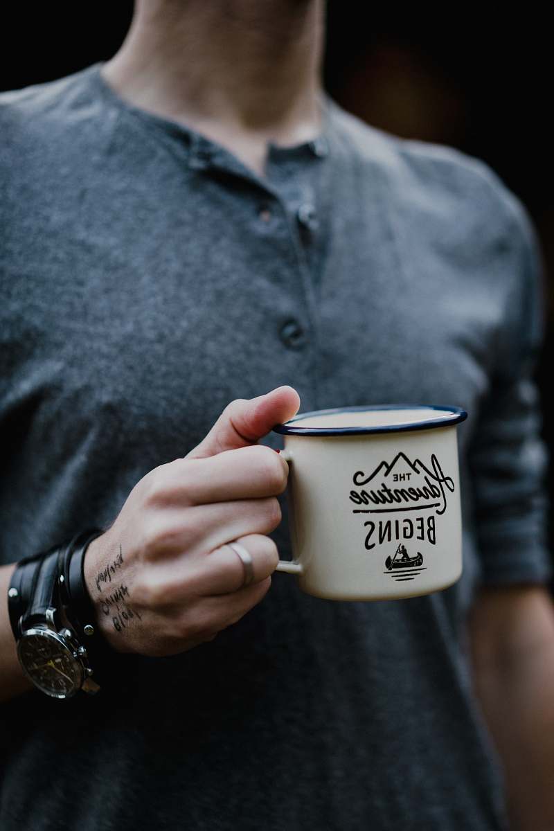 person man holding white ceramic mug cup