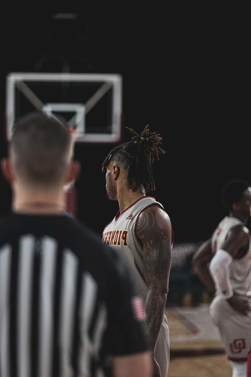 human man in white jersey shirt standing in front of man in black jersey shirt person