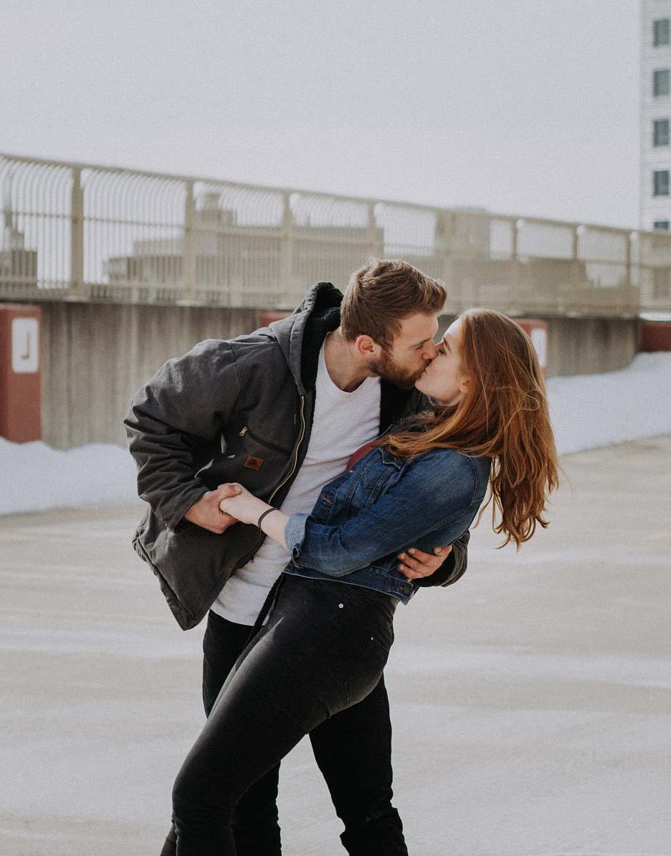 human man kissing woman during daytime person