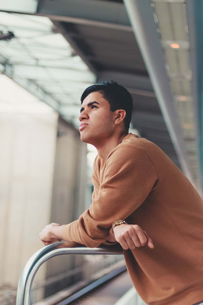 human man leaning on bar while looking upward person