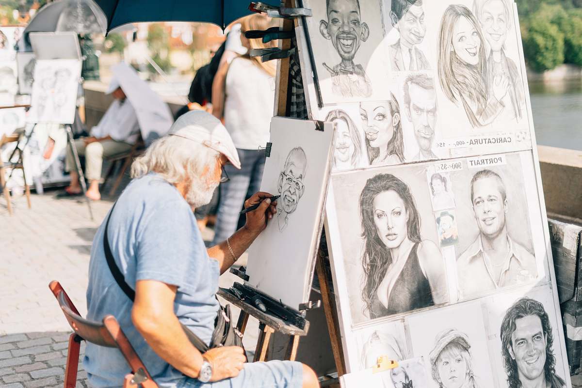 person man sitting on chair sketching a person's face human
