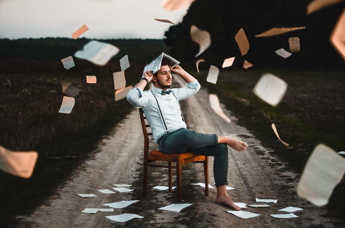 human man sitting on chair with book chair