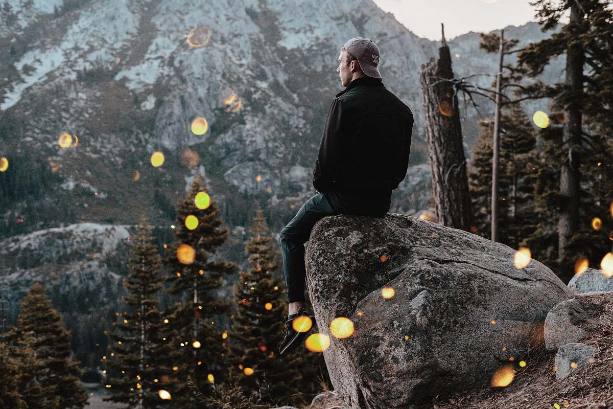 person man sitting on rock human