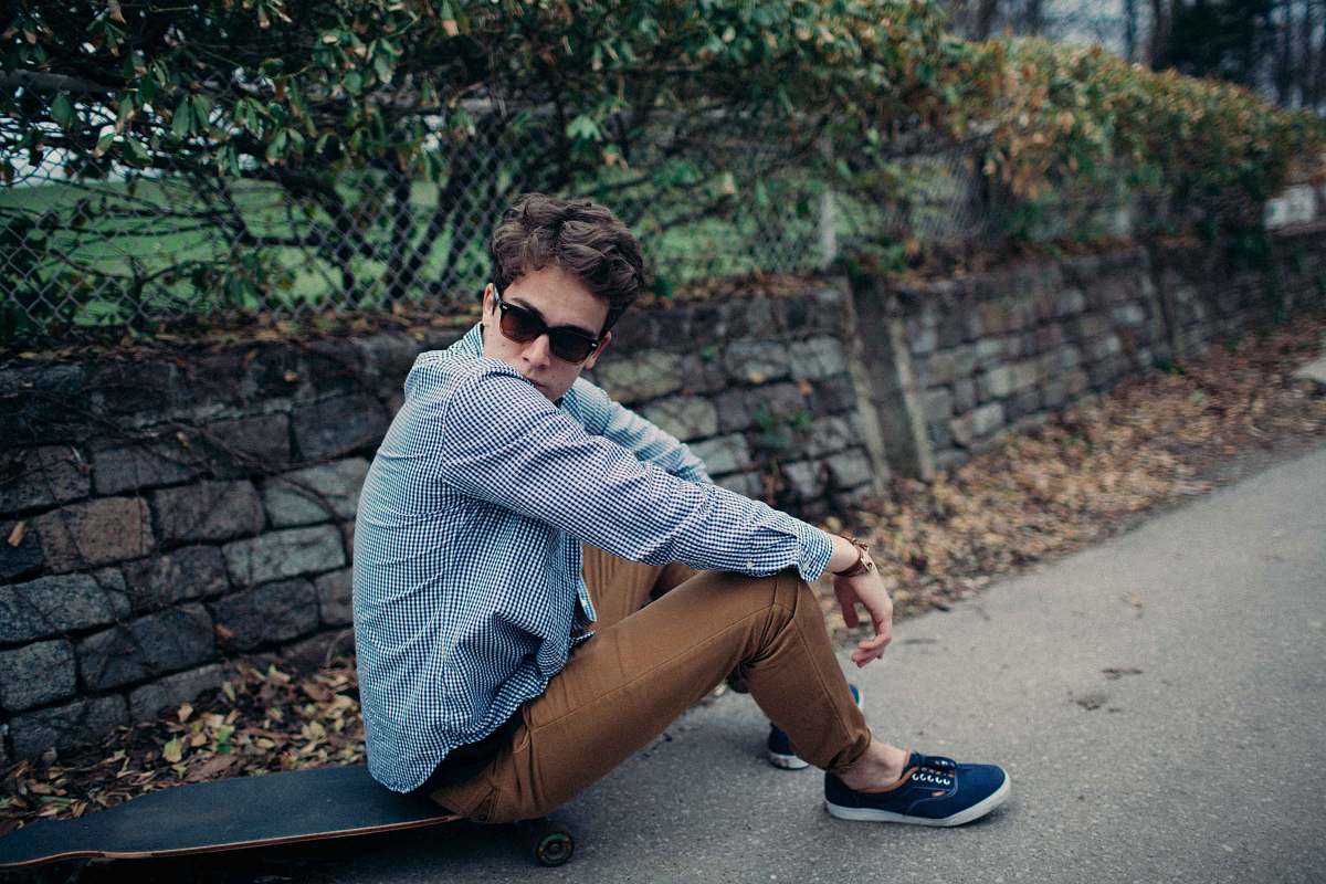 person man sitting on skateboard during daytime human