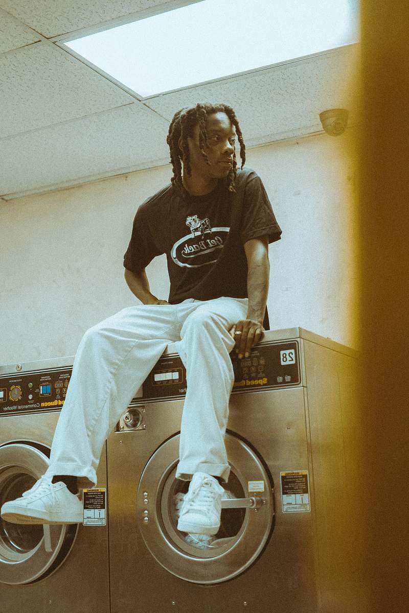 human man sitting on top of front-load clothes washer person