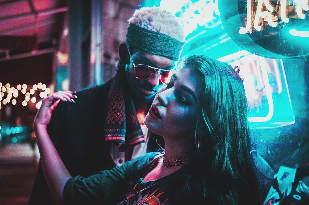 Capture the essence of romance with this enchanting image of a couple sharing a tender kiss late at night in a bustling urban setting. The warm glow of streetlights enhances the intimate moment, making it a perfect visual for themes of love, relationships, and city life. Ideal for use in advertisements, blogs, or social media that celebrate romance or urban nightlife.