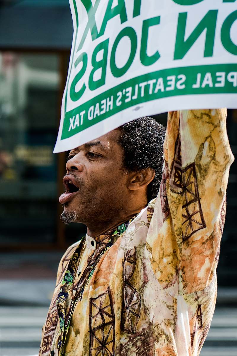 human man standing holding signage shouting person