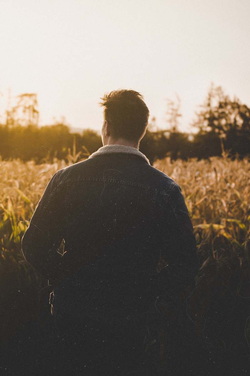 human man standing near grasses back