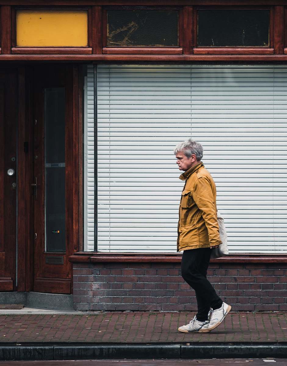 person man walking in front of store human