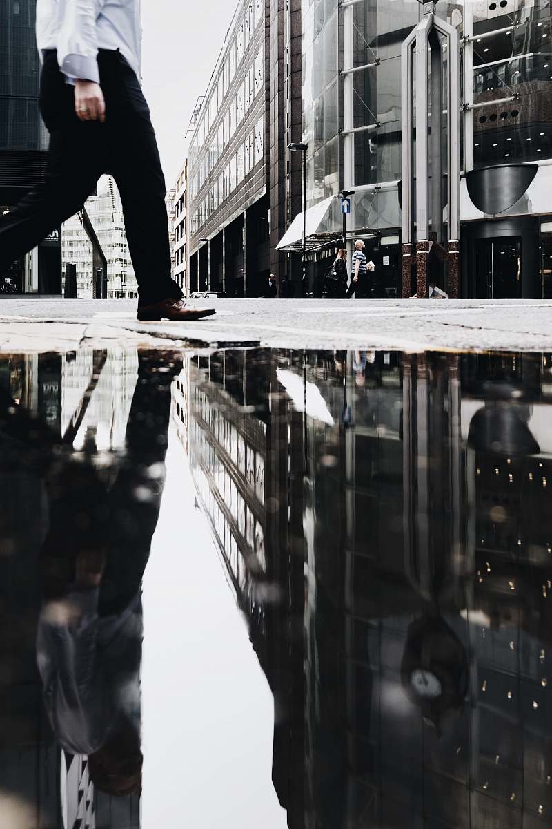 person man walking near puddle of water casting reflection human
