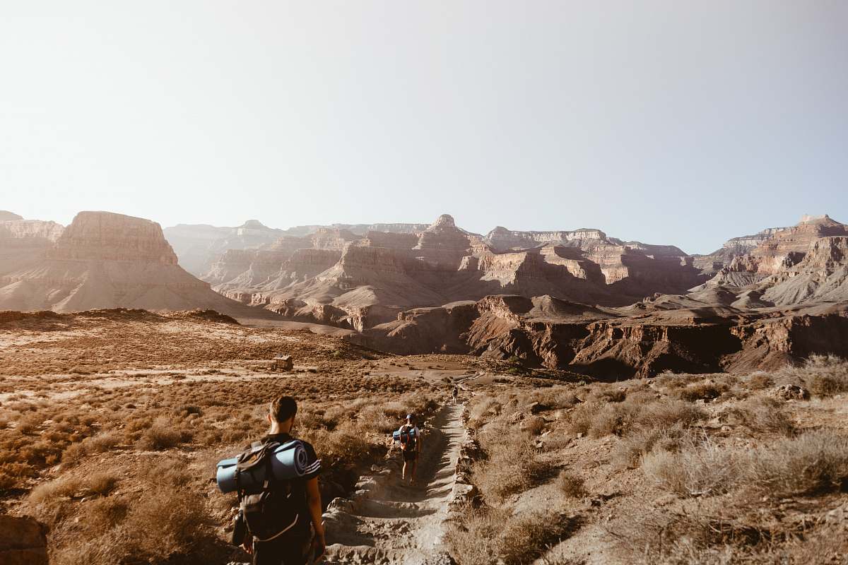 person man walking on empty place surrounded by brown rock formation nature