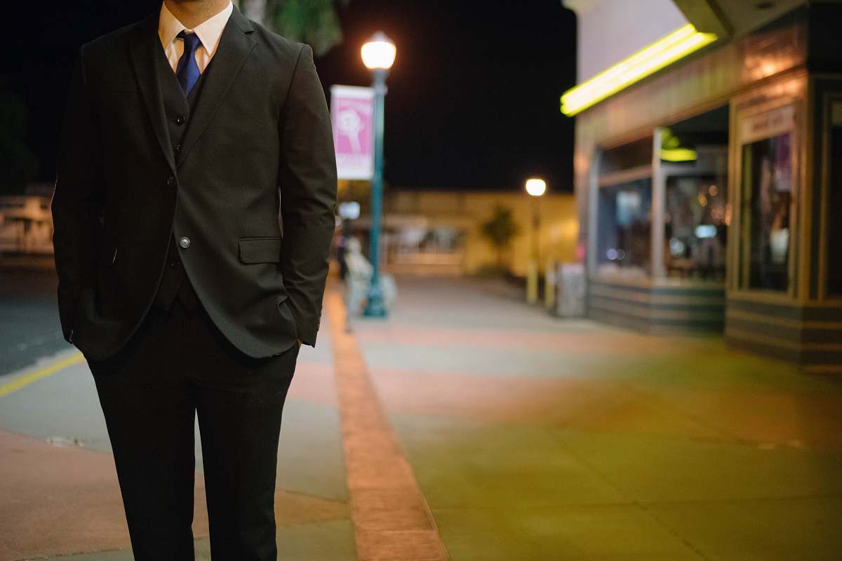 person man walking on standing putting is hands inside pocket suit