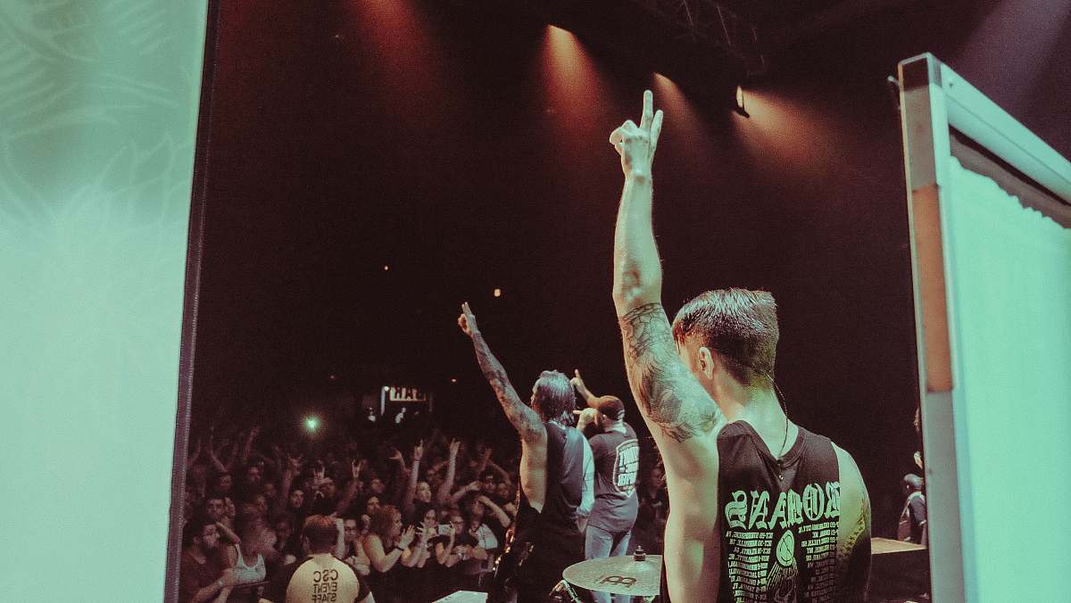 human man wearing black sleeveless shirt with tattoo's on the concert person