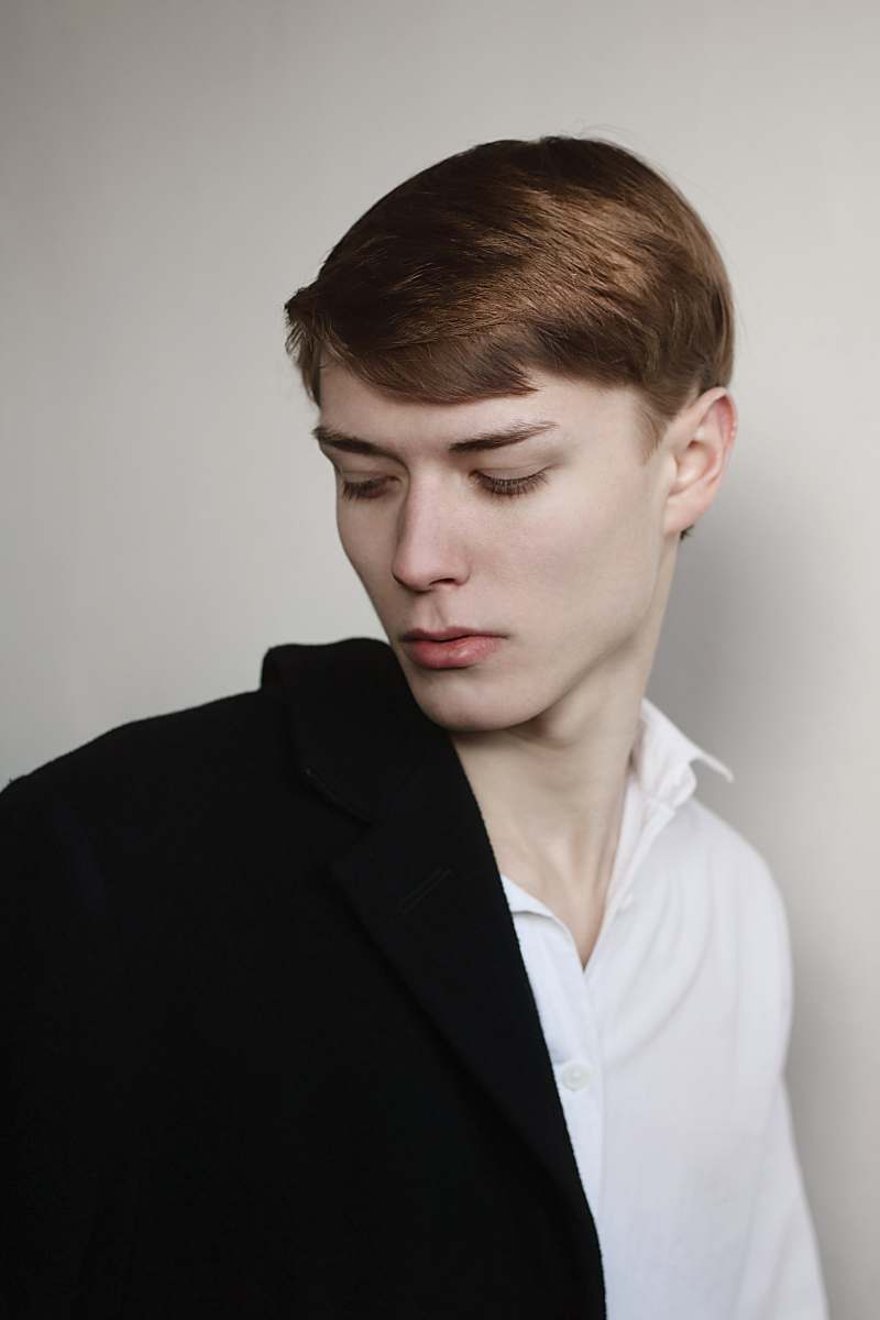 human man wearing black suit jacket looking at left shoulder person
