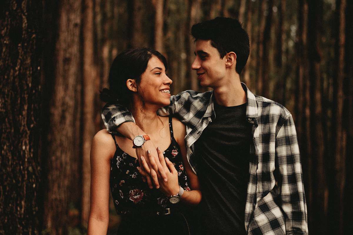 person man wrapping arm on woman facing each other human