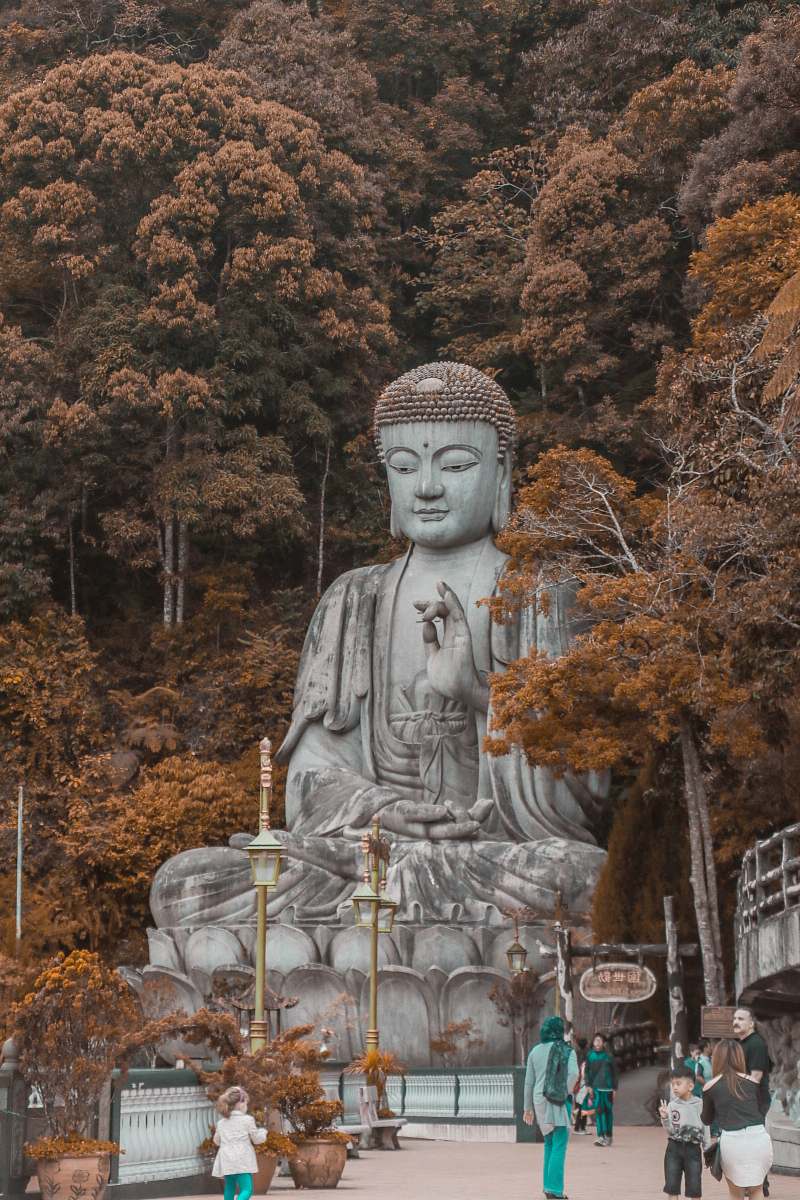 buddha people walking near buddha statue near trees at daytime art