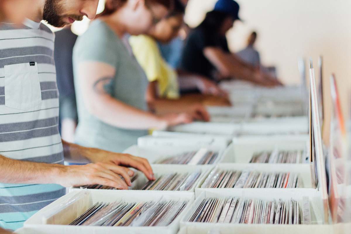 person selective focus photography of group of people selecting vinyl record sleeves human
